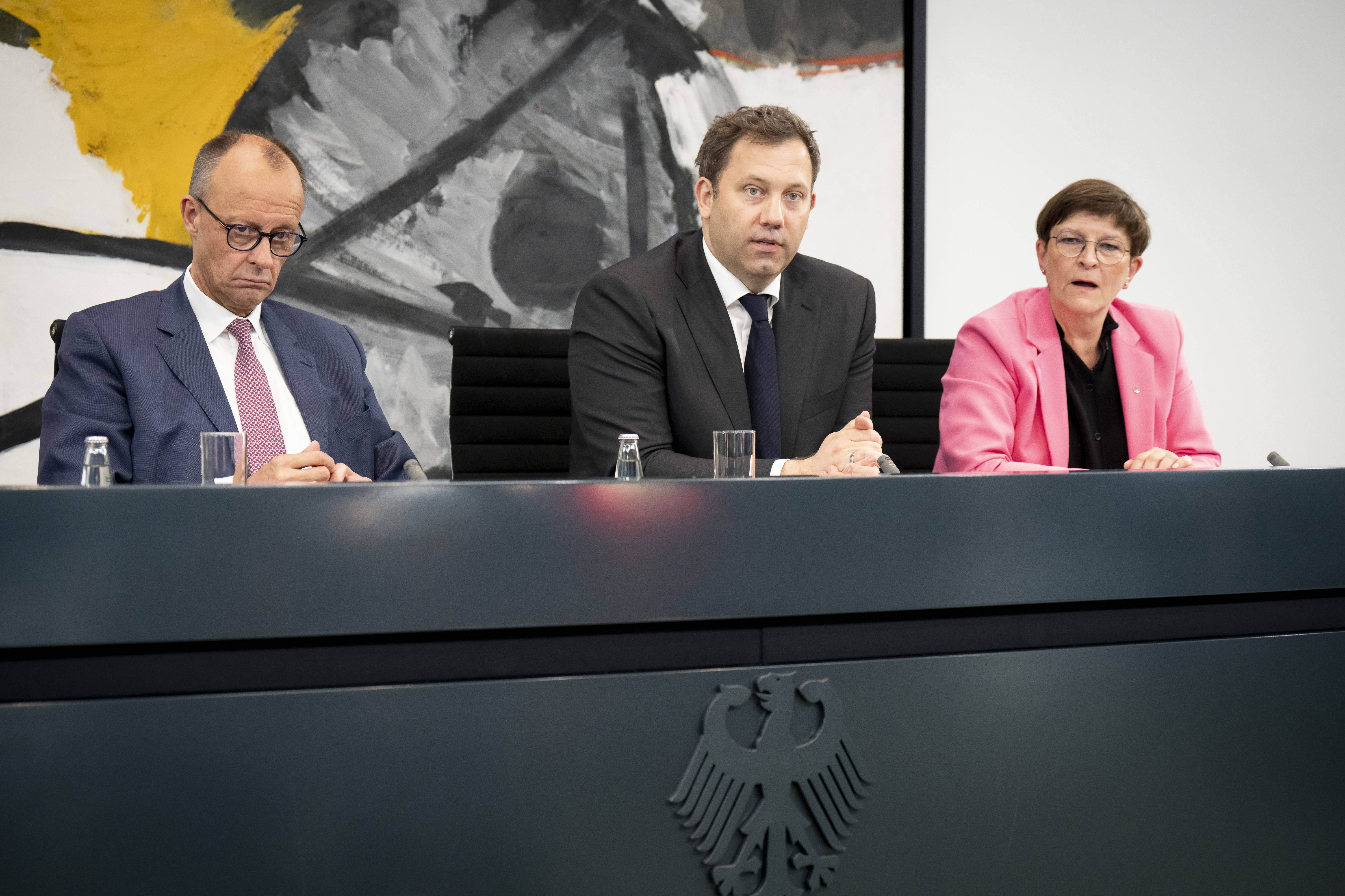 Bundeskanzler Friedrich Merz und die SPD-Vorsitzenden Lars Klingbeil und Saskia Esken sitzen bei einer Pressekonferenz im Kanzleramt.
