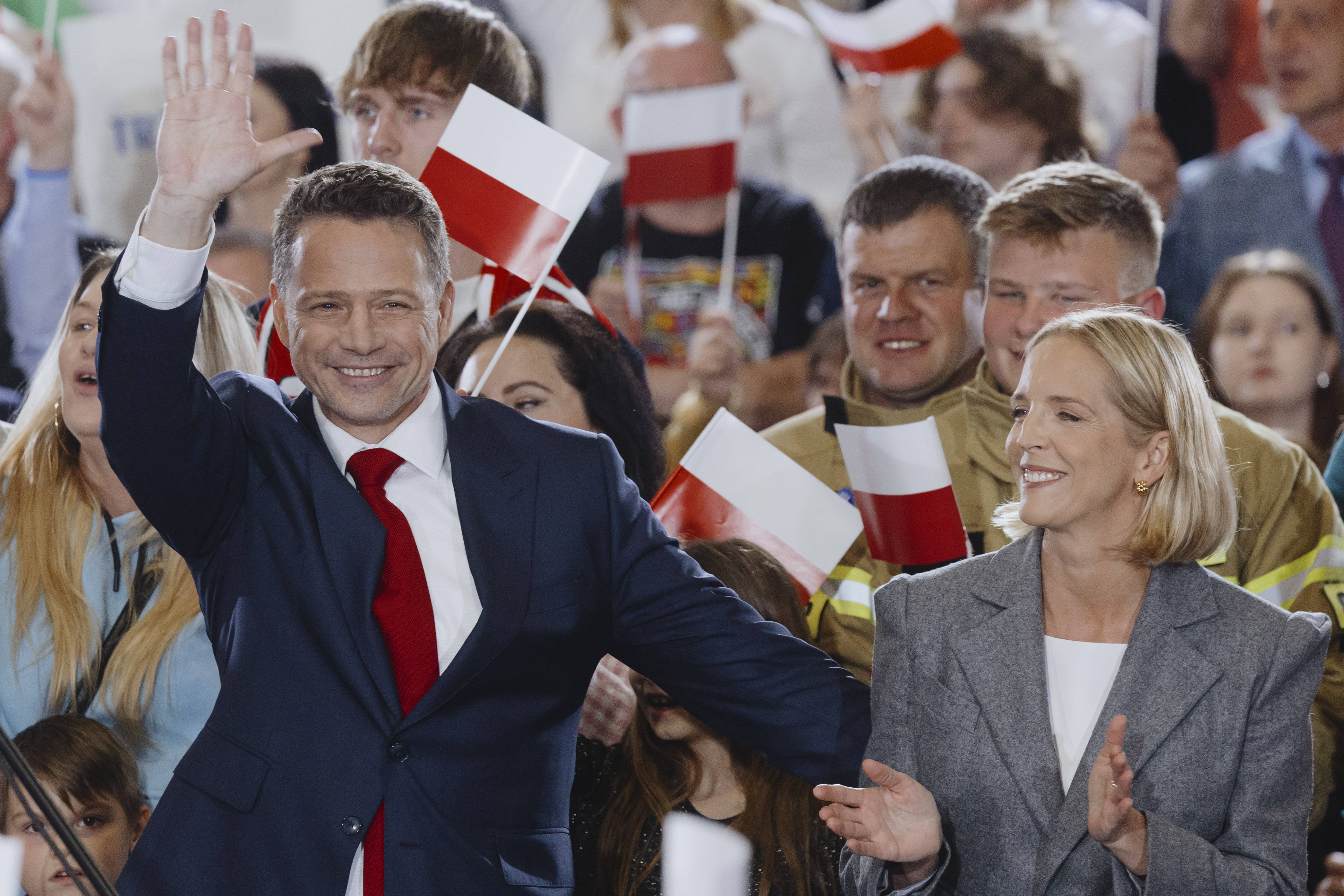 Der amtierende Warschauer Stadtpräsident Rafal Trzaskowski und seine Frau winken in die applaudierende Menge.