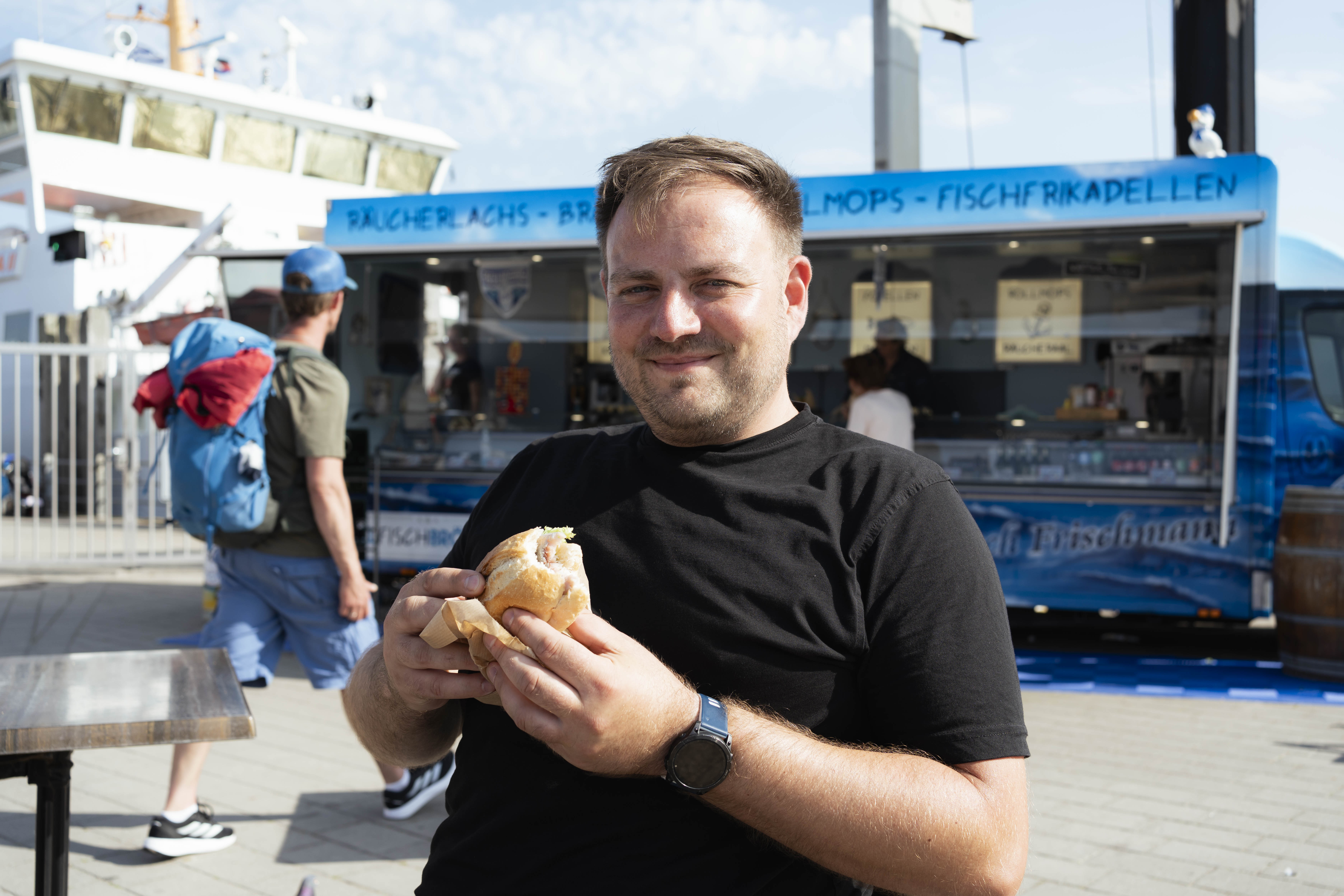 NRW-SPD-Generalsekretär Frederick Cordes isst ein Fischbrötchen auf Norderney.