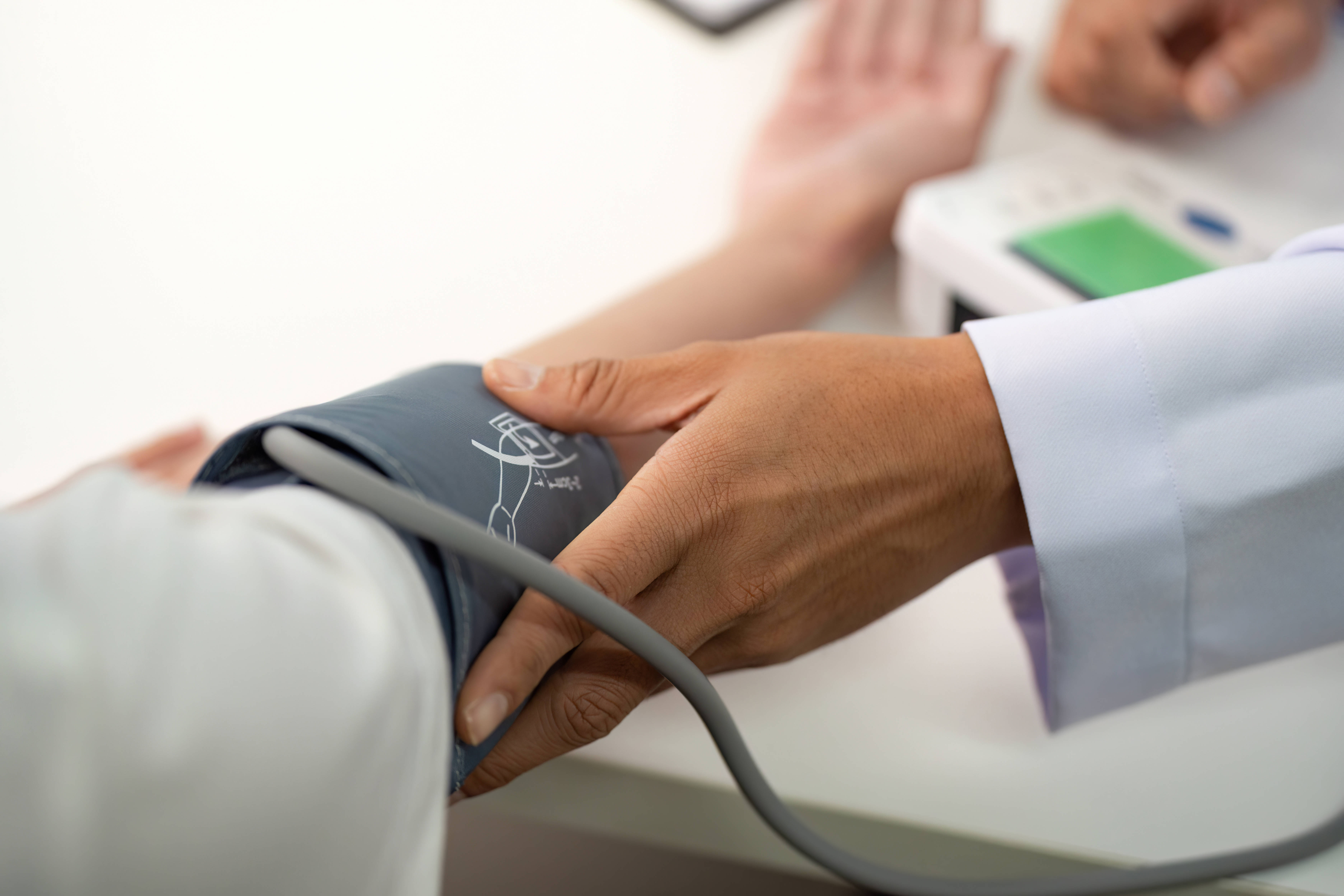 Ein Arzt mit den Blutdruck eines Patienten
