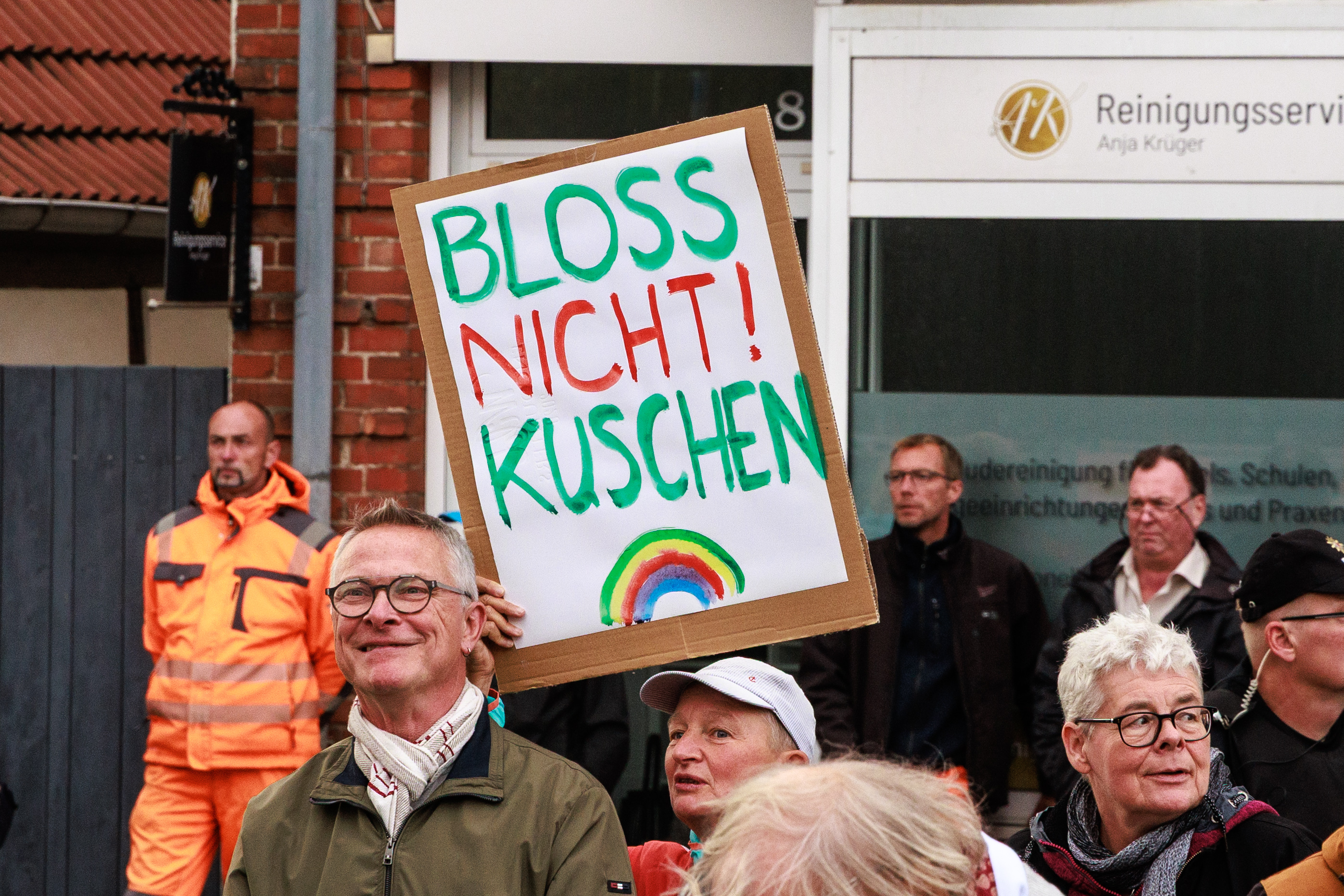Eine Person hält ein Schild mit der Aufschrift: "Bloss nicht kuschen!"