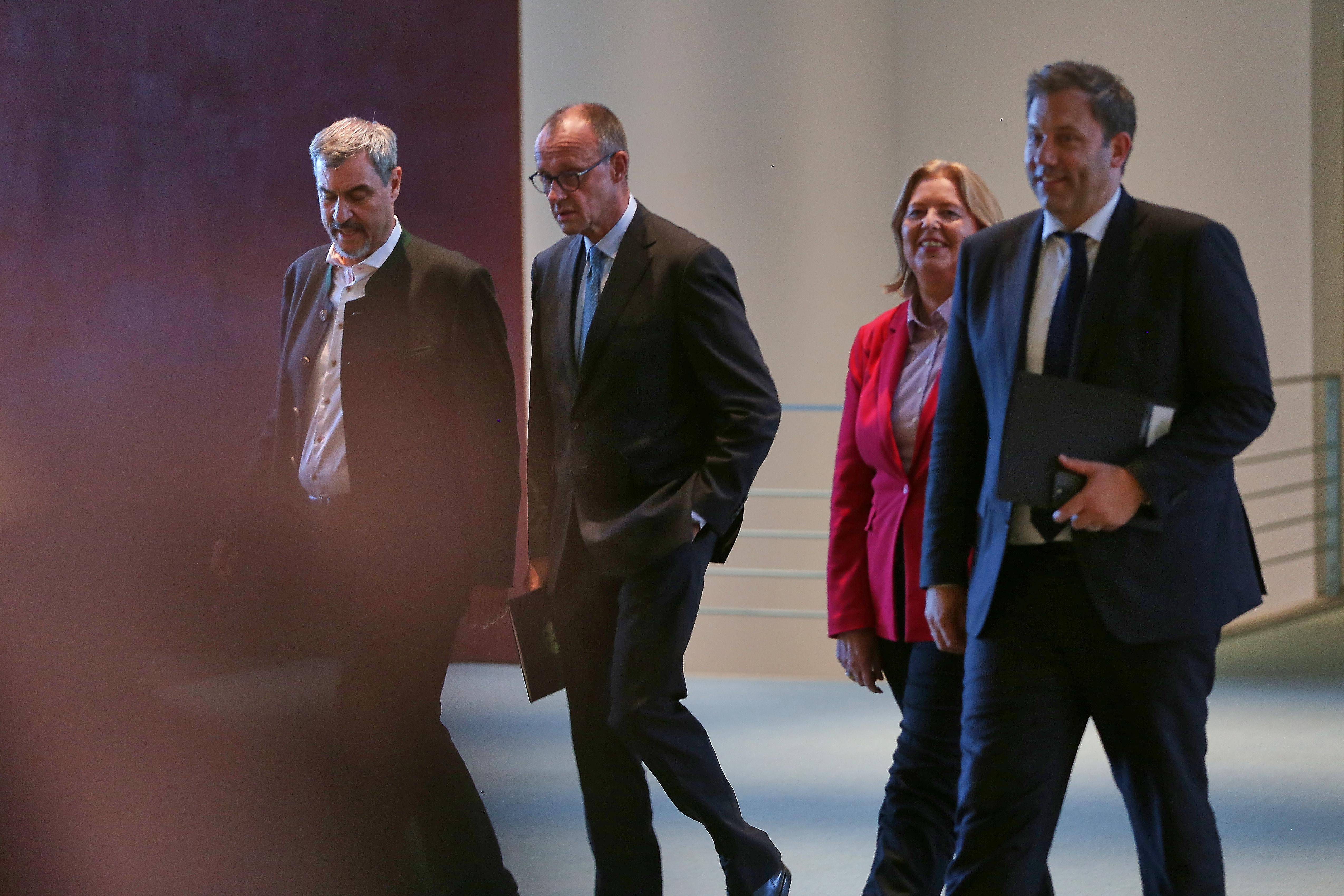 Markus Söder, Friedrich Merz, Bärbel Bas und Lars Klingbeil laufen nebeneinander einen Gang entlang.
