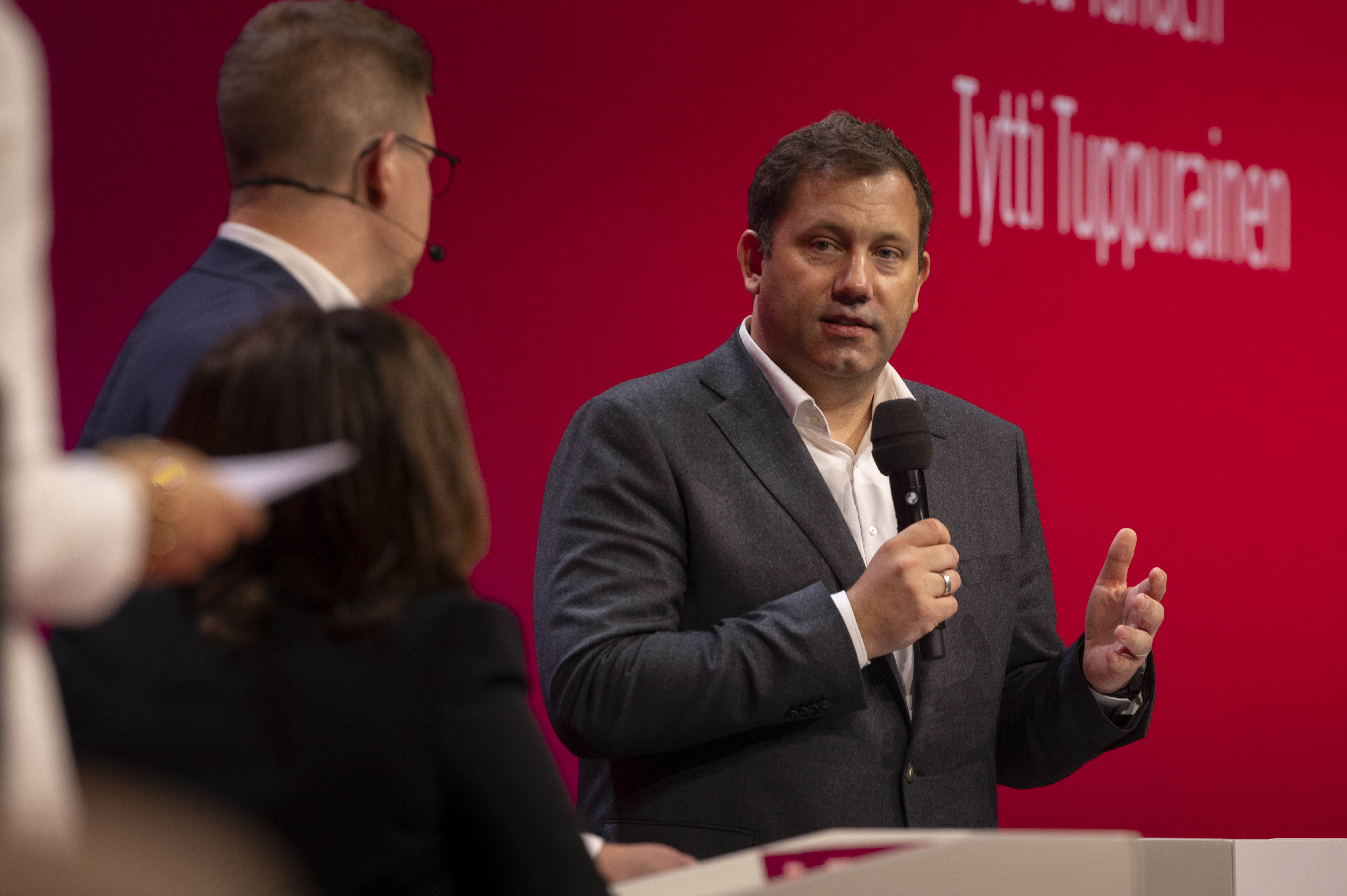 SPD-Chef Lars Klingbeil mit Mikrofon in der Hand vor einem roten Hintergrund