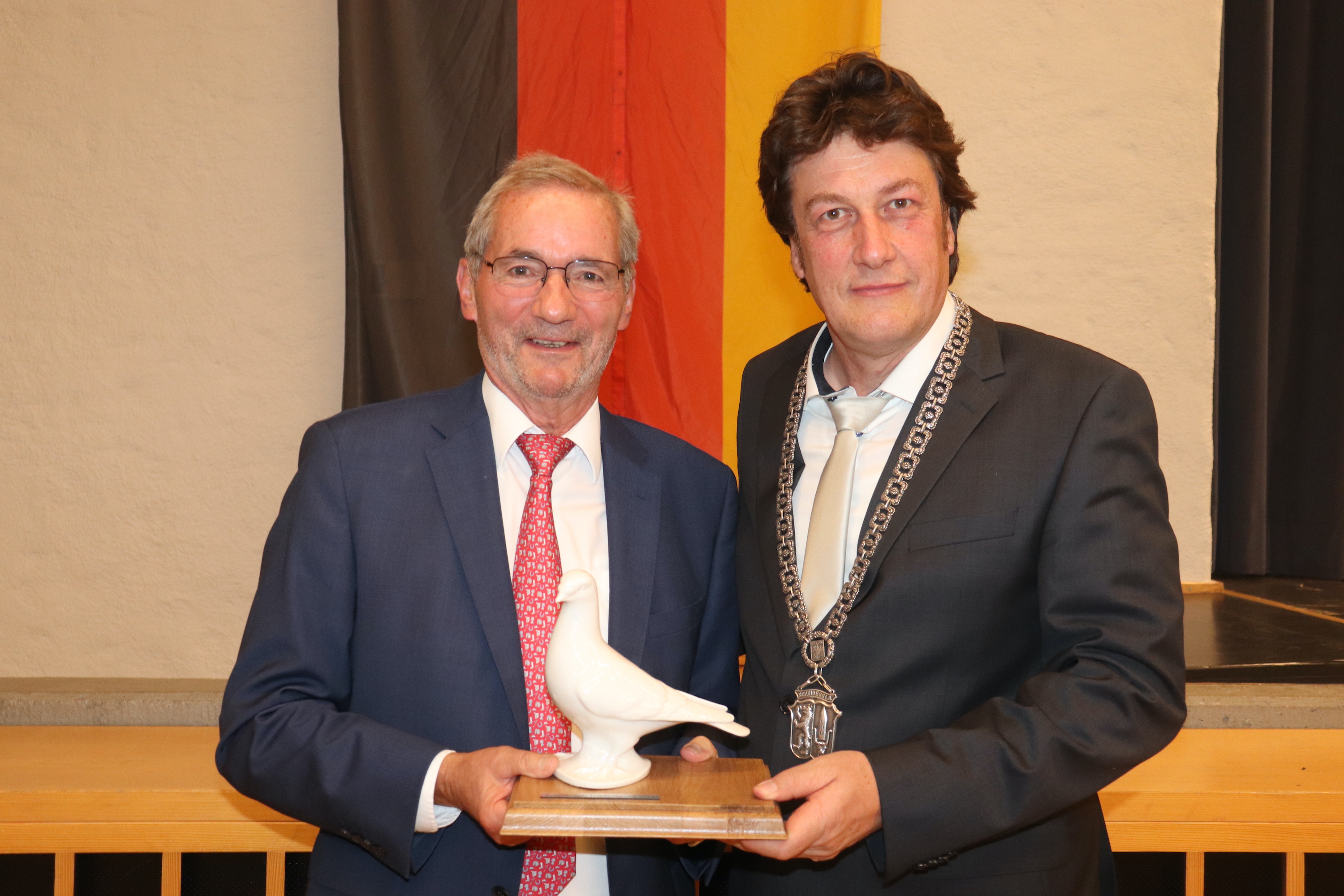 Matthias Platzeck und Scheideggs Bürgermeister Ulrich Pfanner halten den Scheidegger Friedenspreis, eine weiße Taube.