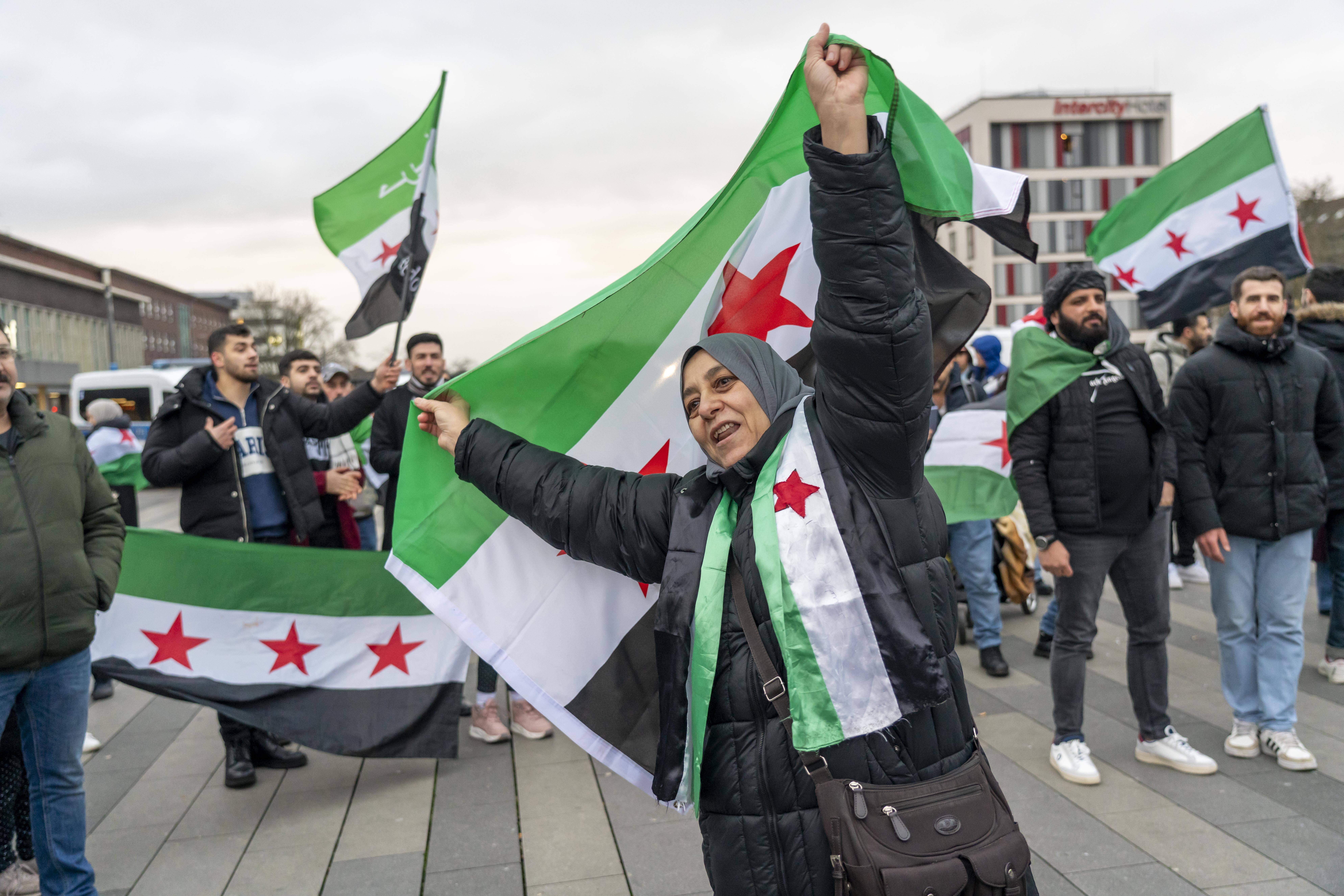 Syrer*innen feiern nach dem Sturz des Assad-Regimes auf dem Vorplatz des Duisburger Hauptbahnhofs.