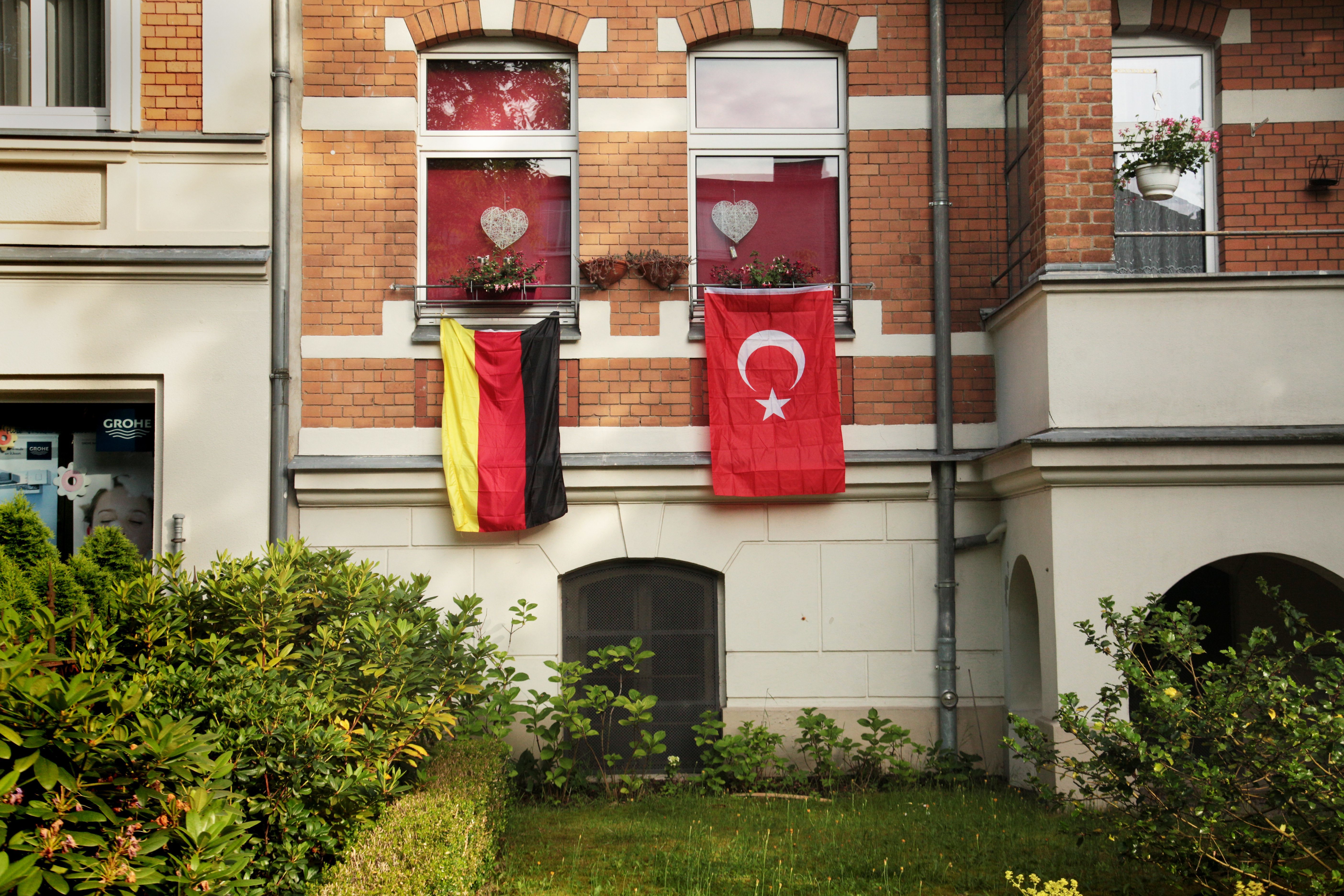 Eine deutsche und eine türkische Flagge an einem Wohnhaus