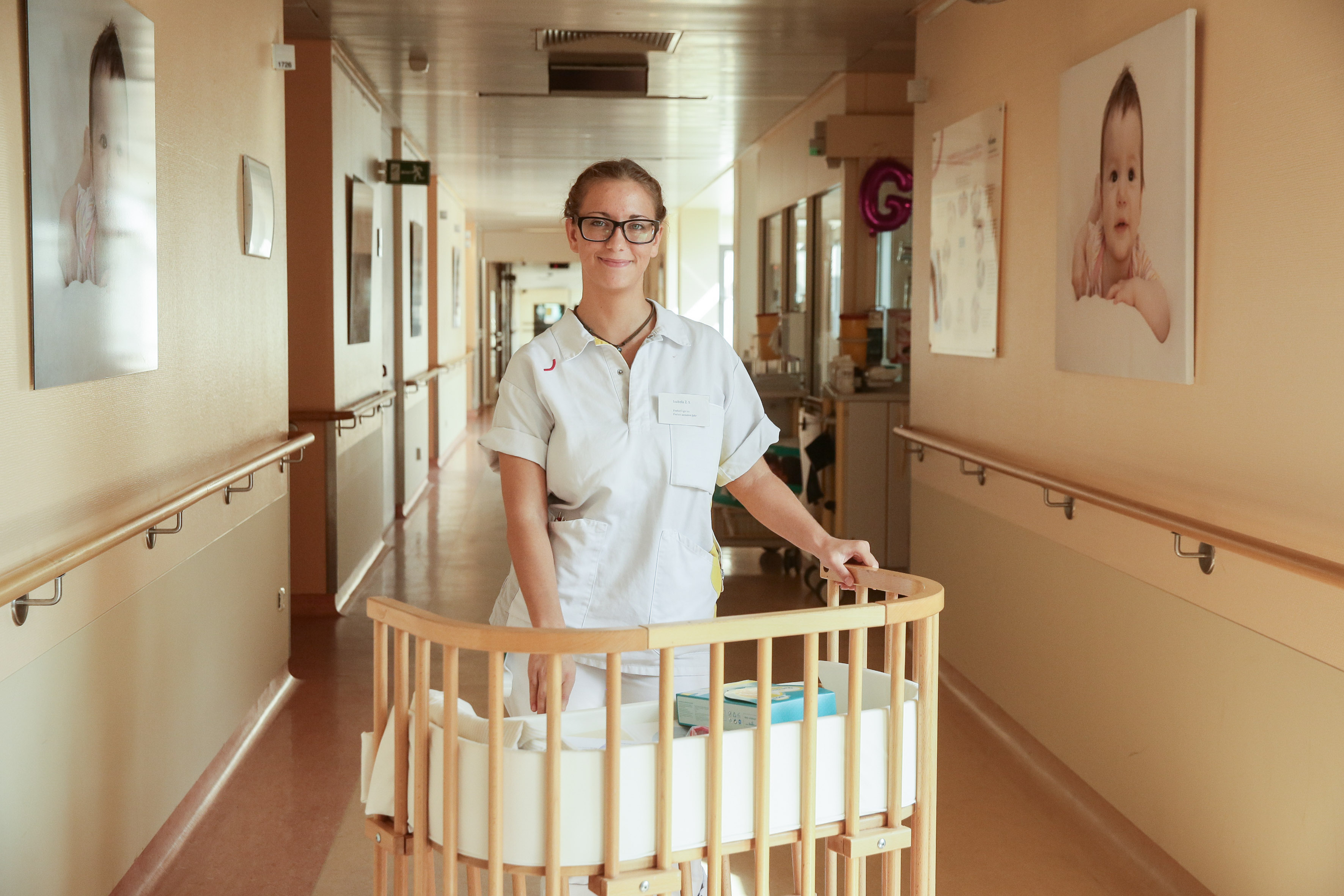 Izabela Styrna schiebt ein Kinderbett durch den Flur der Klinik