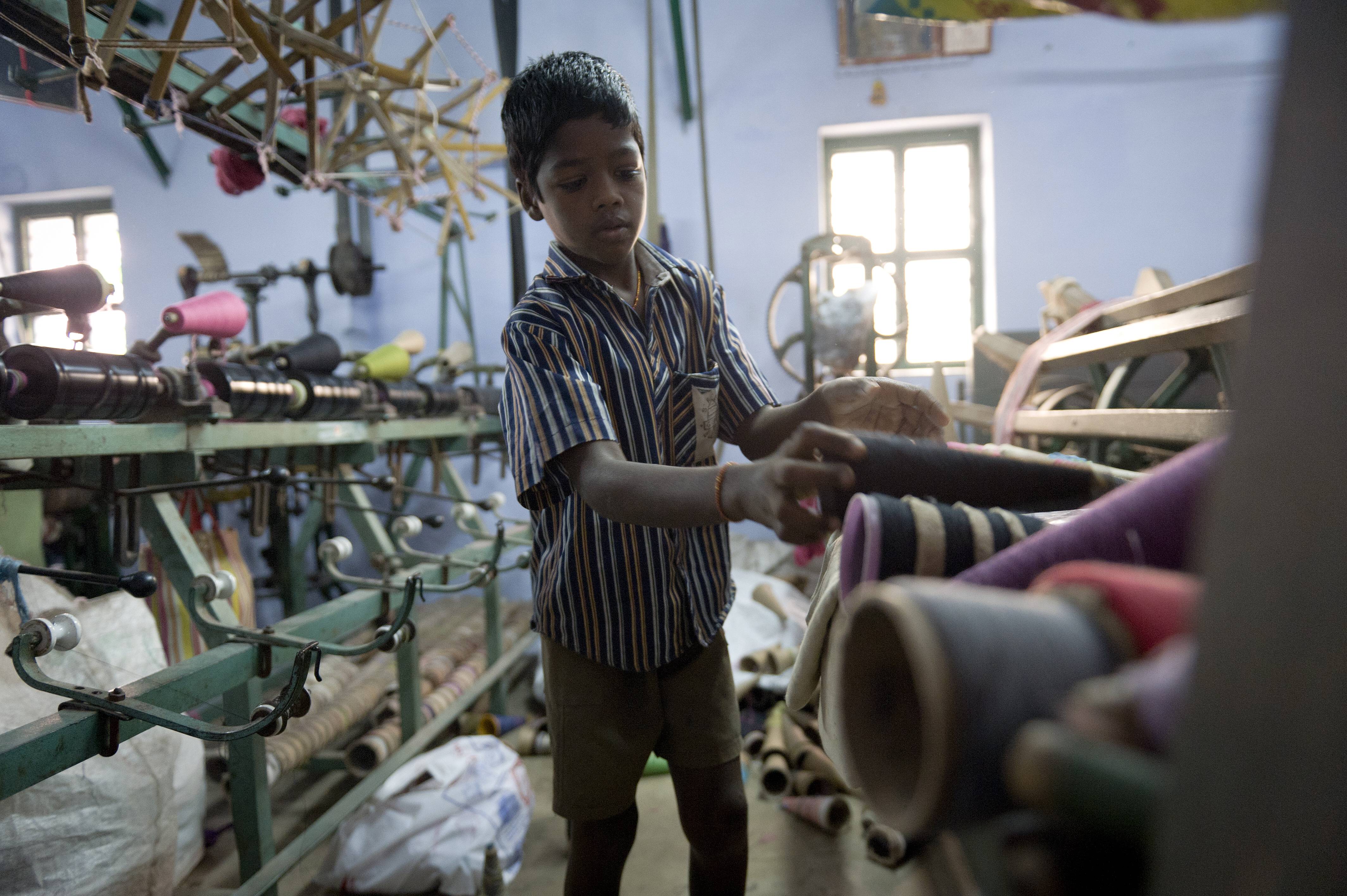 Ein 11-jähriger Kinderarbeiter bedient eine Maschine in einer Moskitonetz-Fabrik im südindischen Tamil Nadu.