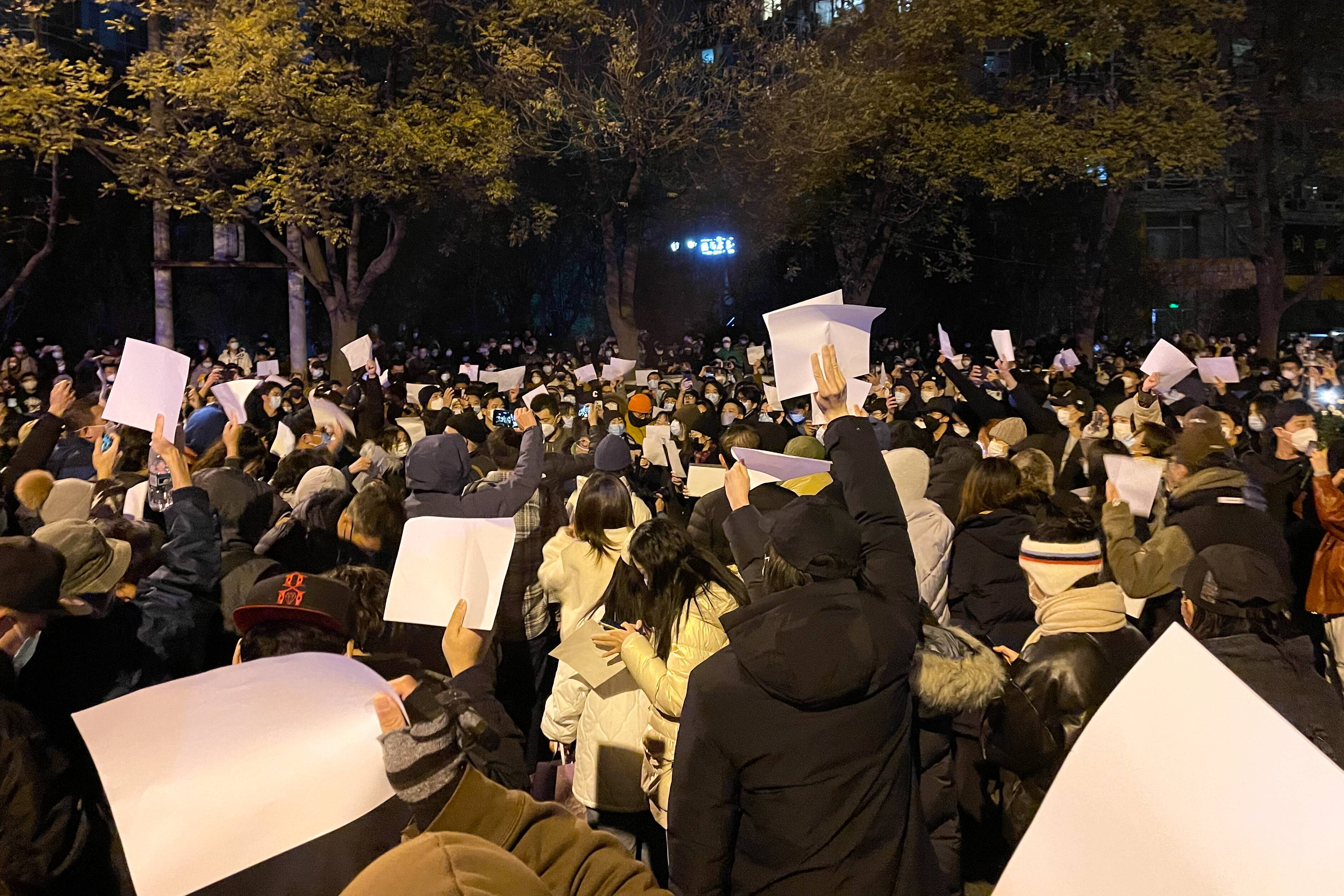 Protest in Peking: Menschen halten weiße Blätter in die Höhe.