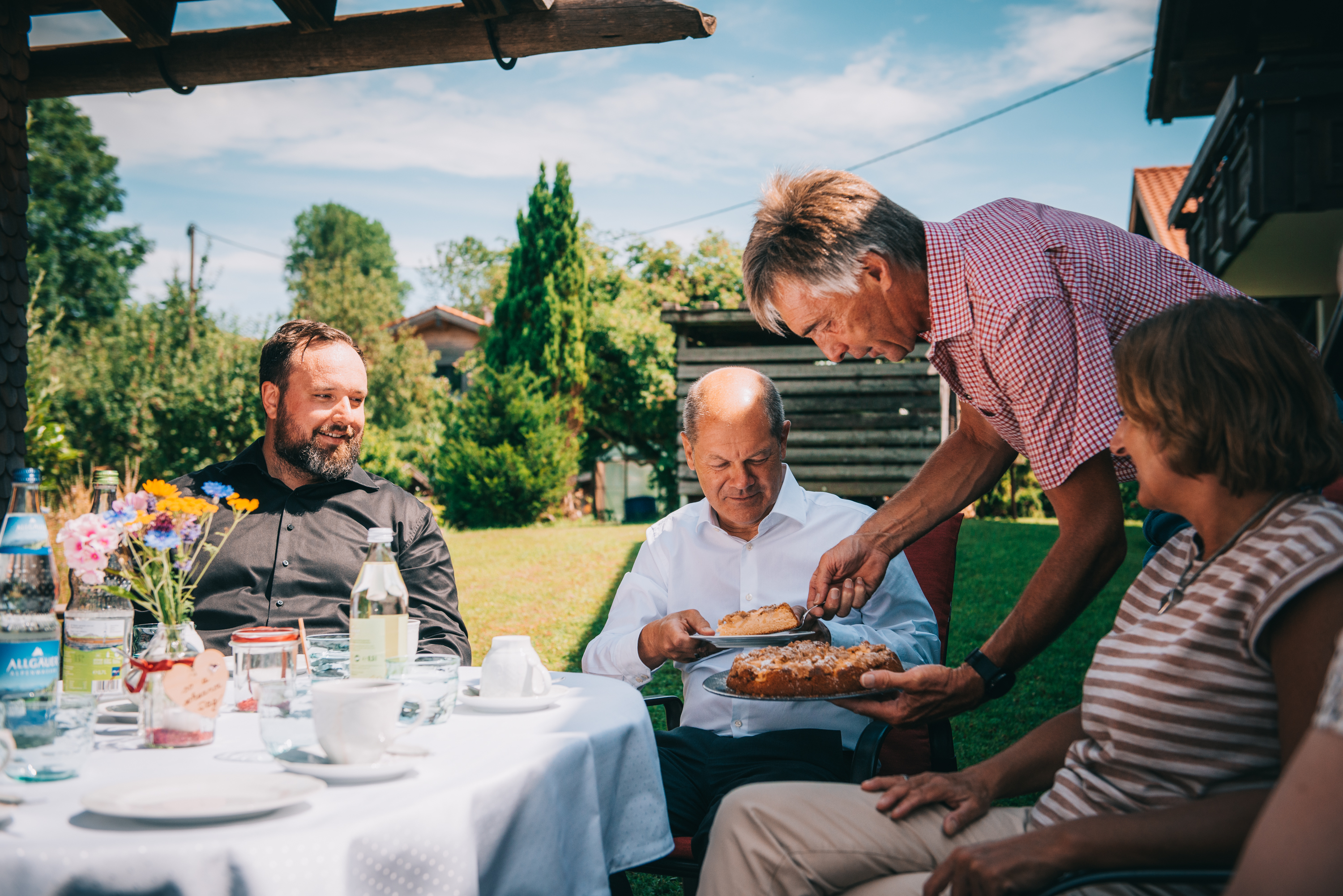 Bundeskanzler Olaf Scholz und Britta Ernst zu Gast im Garten von Max Roth (links).