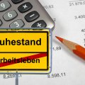 Computergeneriertes Ortsausgangsschilt mit der Aufschrift "Ruhestand" und dem durchgestrichenen Wort "Arbeitsleben", im Hintergrund ein roter Stift und ein Taschenrechner