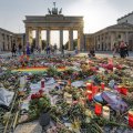 Ein Blumenmeer vor dem Brandenburger Tor im Gegenlicht erinnert an die Opfer des Anschlags auf den Berliner CSD.