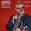 Entertainer Hape Kerkeling mit Mikrofon vor einer Wand mit der Aufschrift "SPD-Bundestagsfraktion"