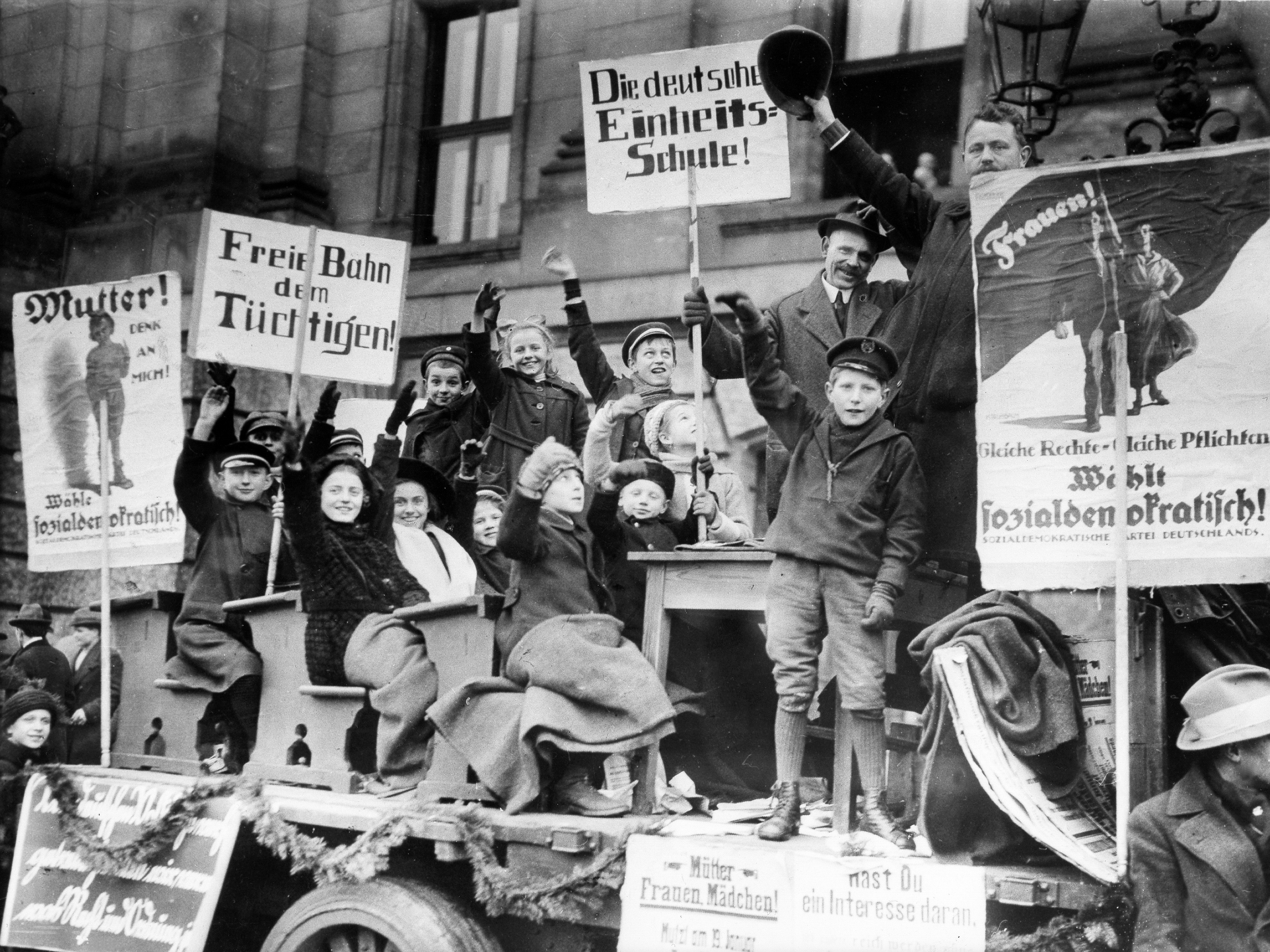 Ein Wagen aus einem Werbeumzug der SPD mit der Forderung nach Einfuehrung der Einheitsschule und mit einem Hinweis auf das Frauenwahlrecht - Anfang Januar 1919 - 10.01.1919